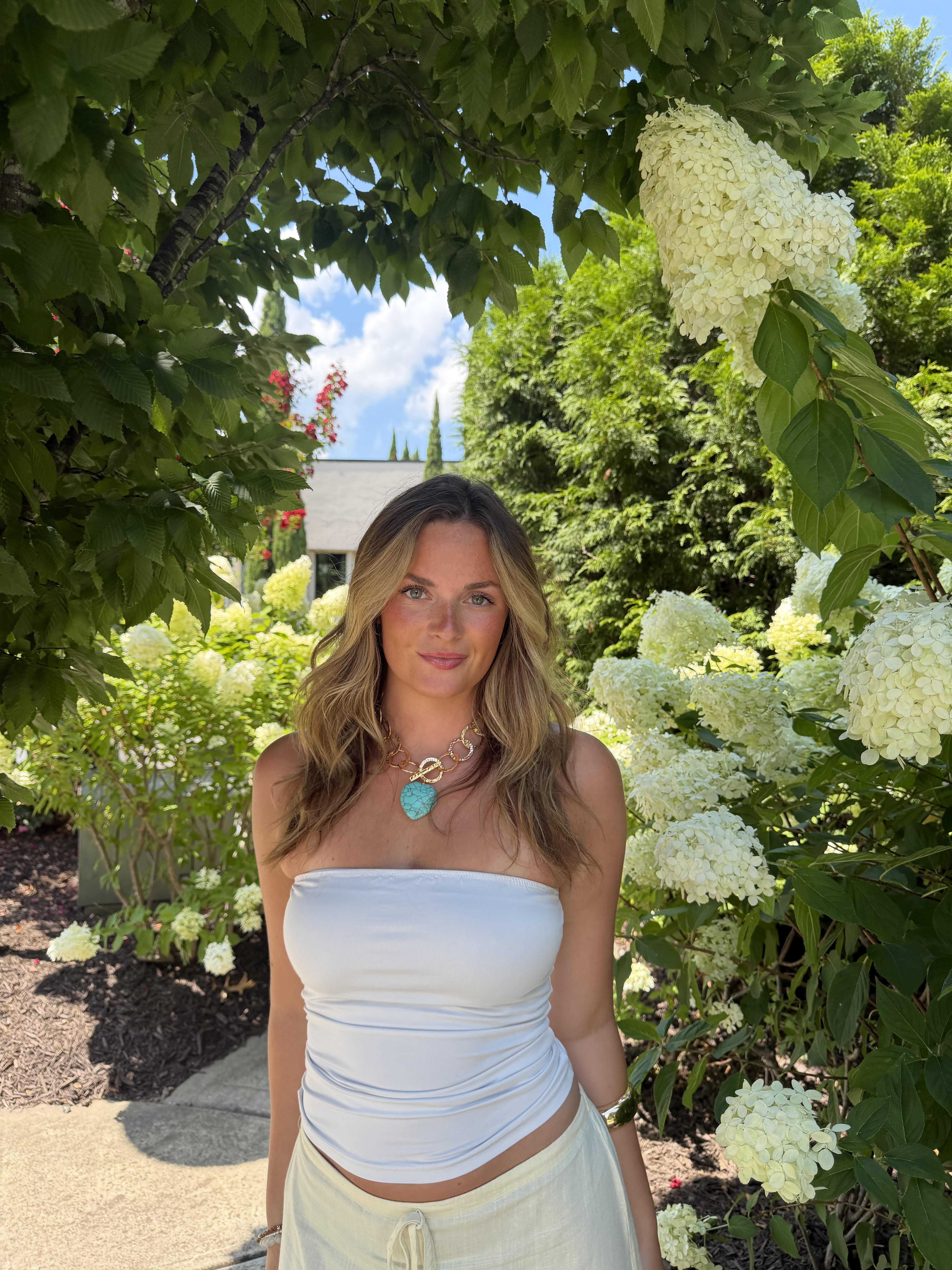 Maycee Fundora, founder of Lighthouse Social, standing in a garden